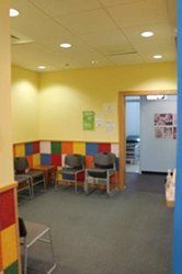 A waiting room with chairs and tables in a hospital.