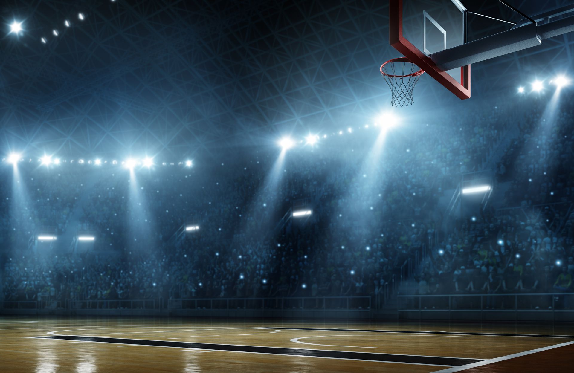 Basketball court with bright overhead lights, empty arena, and a hoop.