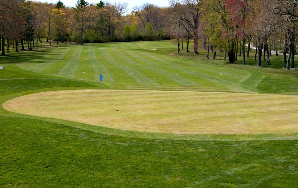 A golf course with a blue flag in the middle of it