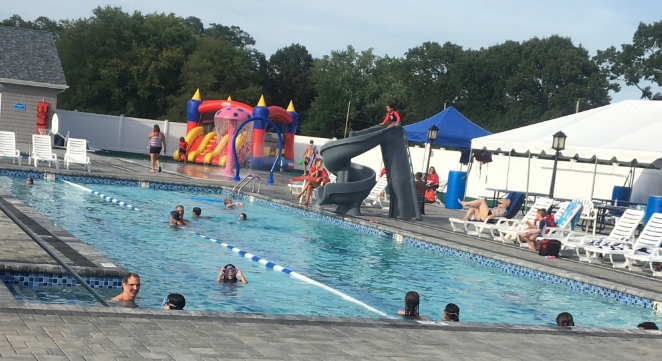 A group of people are swimming in a large swimming pool.