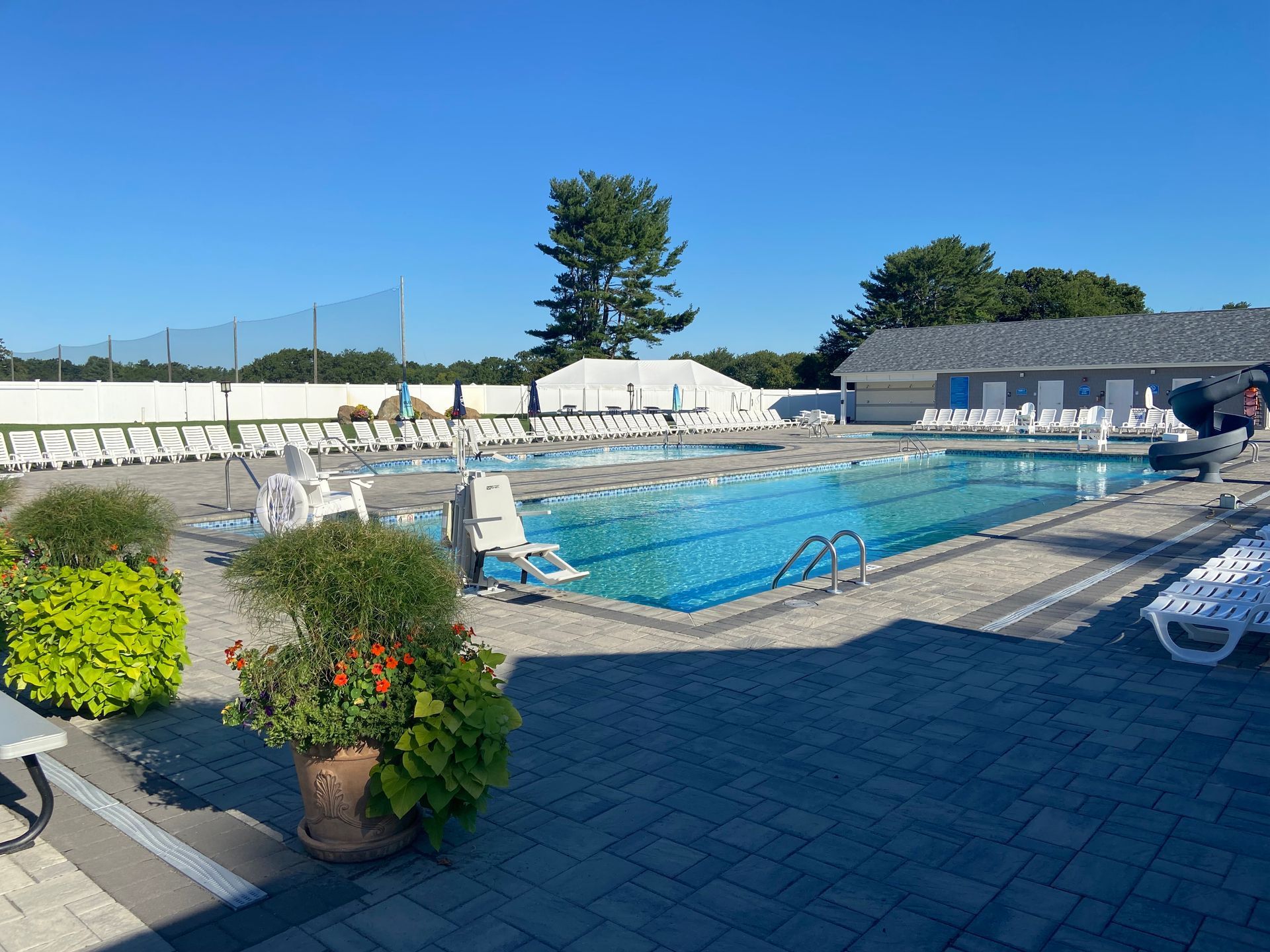 A large swimming pool with a lot of chairs around it