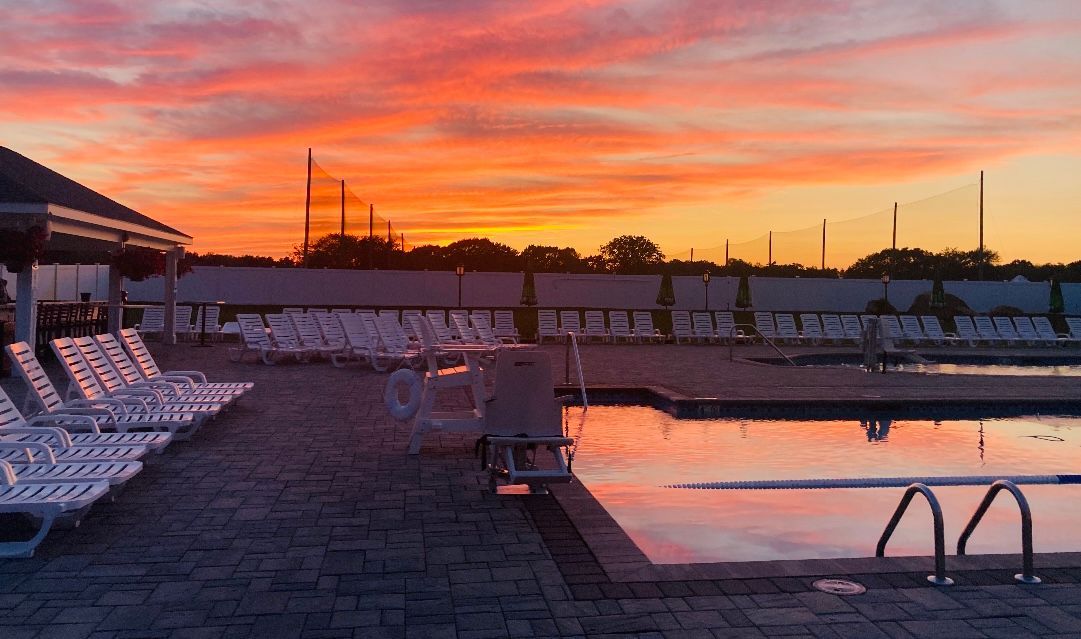 A swimming pool with a sunset in the background.