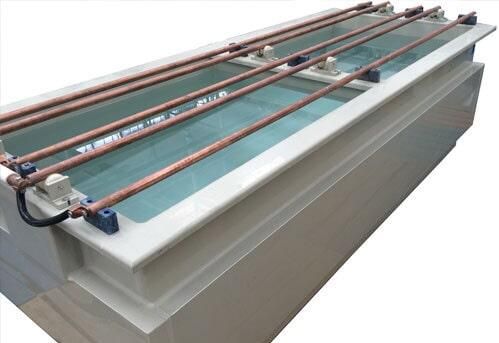 Tanque industrial rectangular con tubos de cobre, apto para galvanoplastia o limpieza de piezas metálicas.