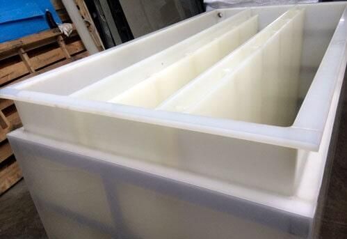 Tanque de plástico rectangular de color blanco con divisores interiores.