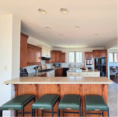 Kitchen with wood cabinets, island, and green stools.
