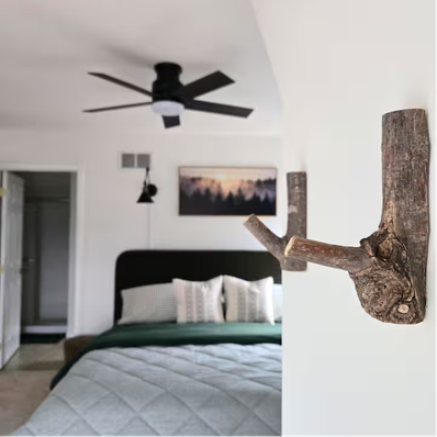 Rustic branch wall hooks in front of modern bedroom.