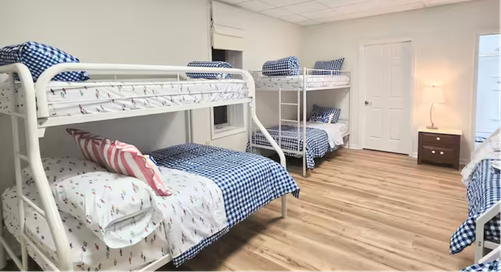 Bedroom with two white bunk beds and navy patterned bedding.