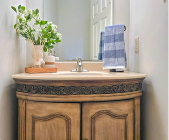 Bathroom with wood vanity, stone countertop, and sink.
