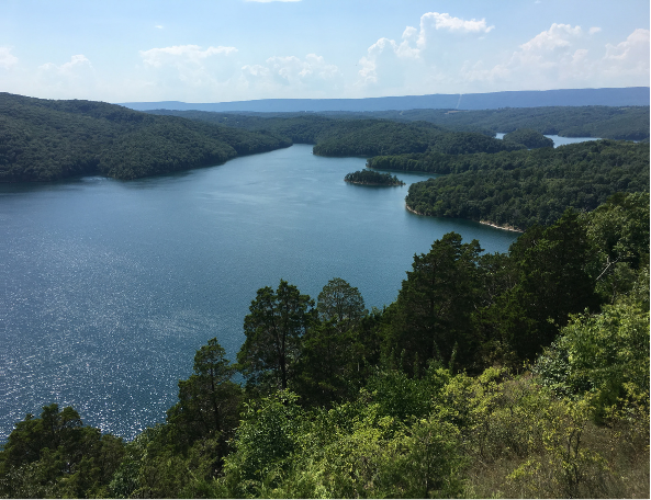 High-angle view of blue mountain lake surrounded by green forest.