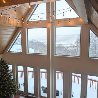 Triangular room with floor-to-ceiling windows and snowy view.
