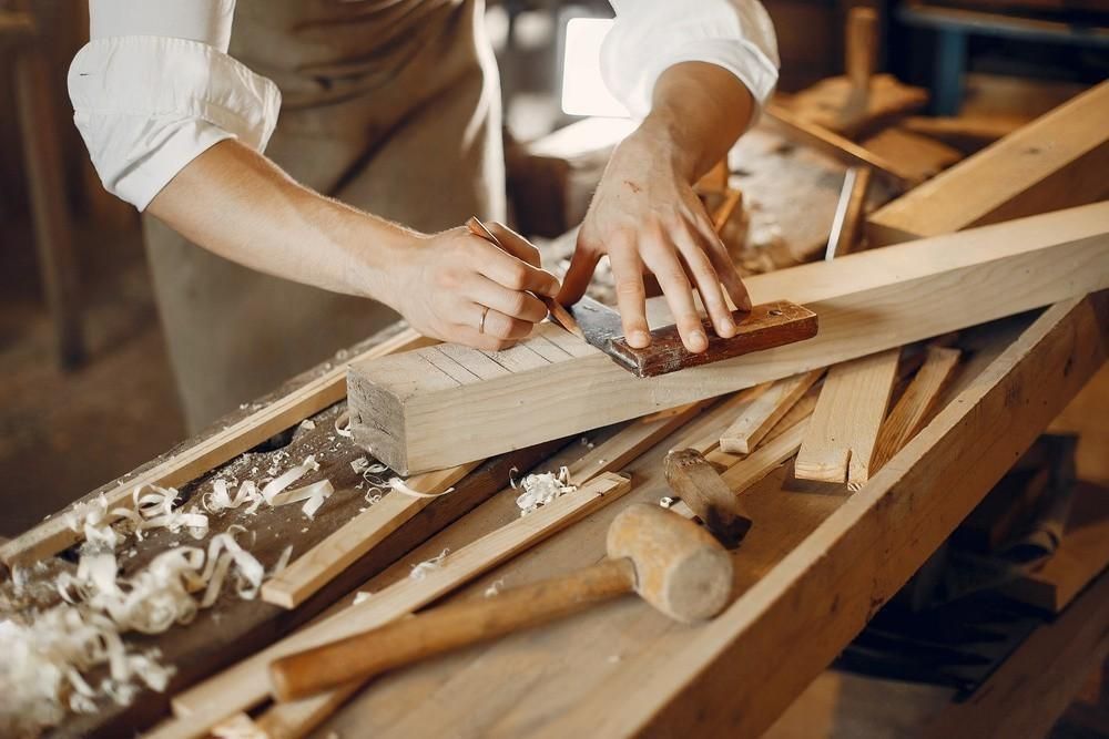 a man is working on a piece of wood in a workshop .