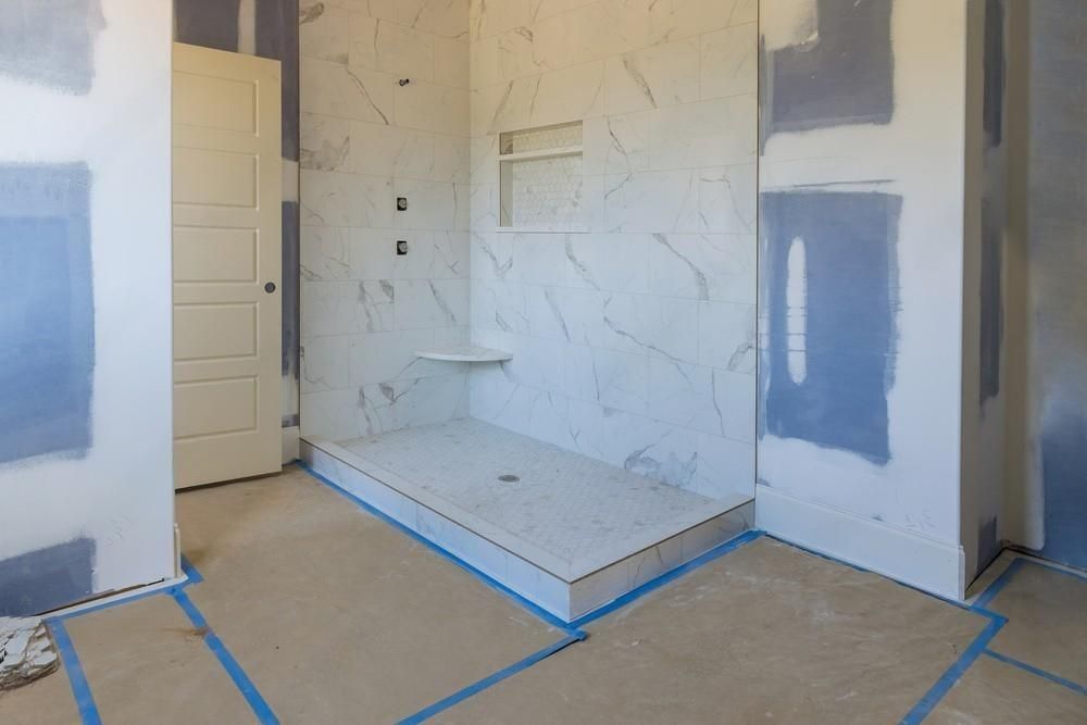 a bathroom under construction with a walk in shower .