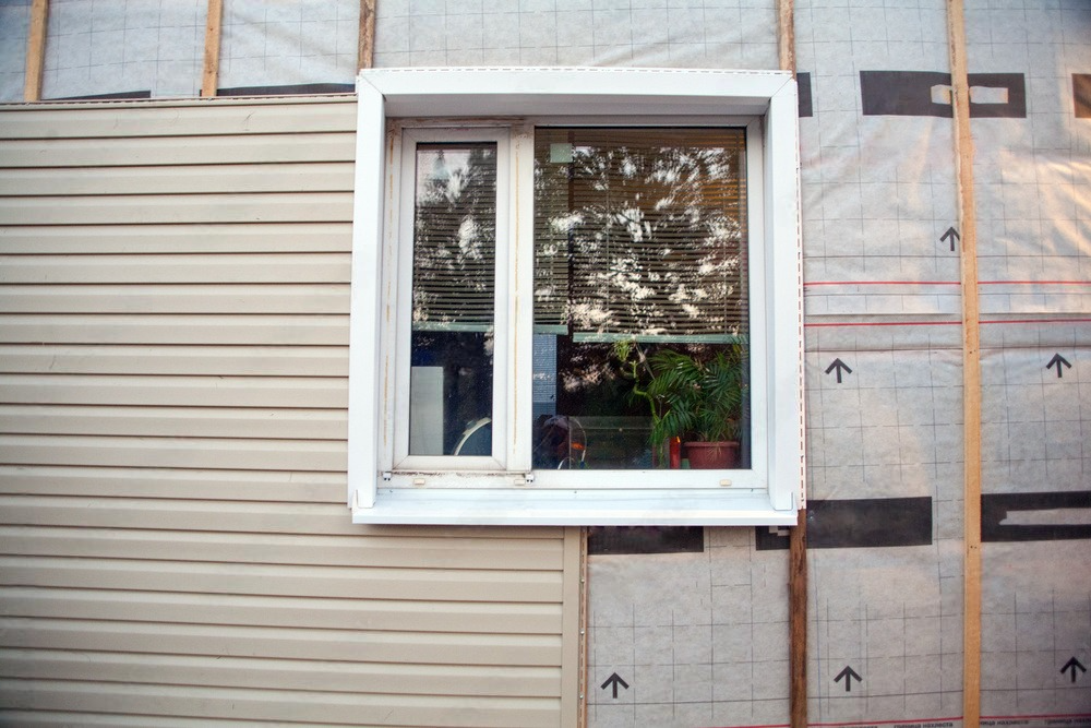 a window is being installed on the side of a house .