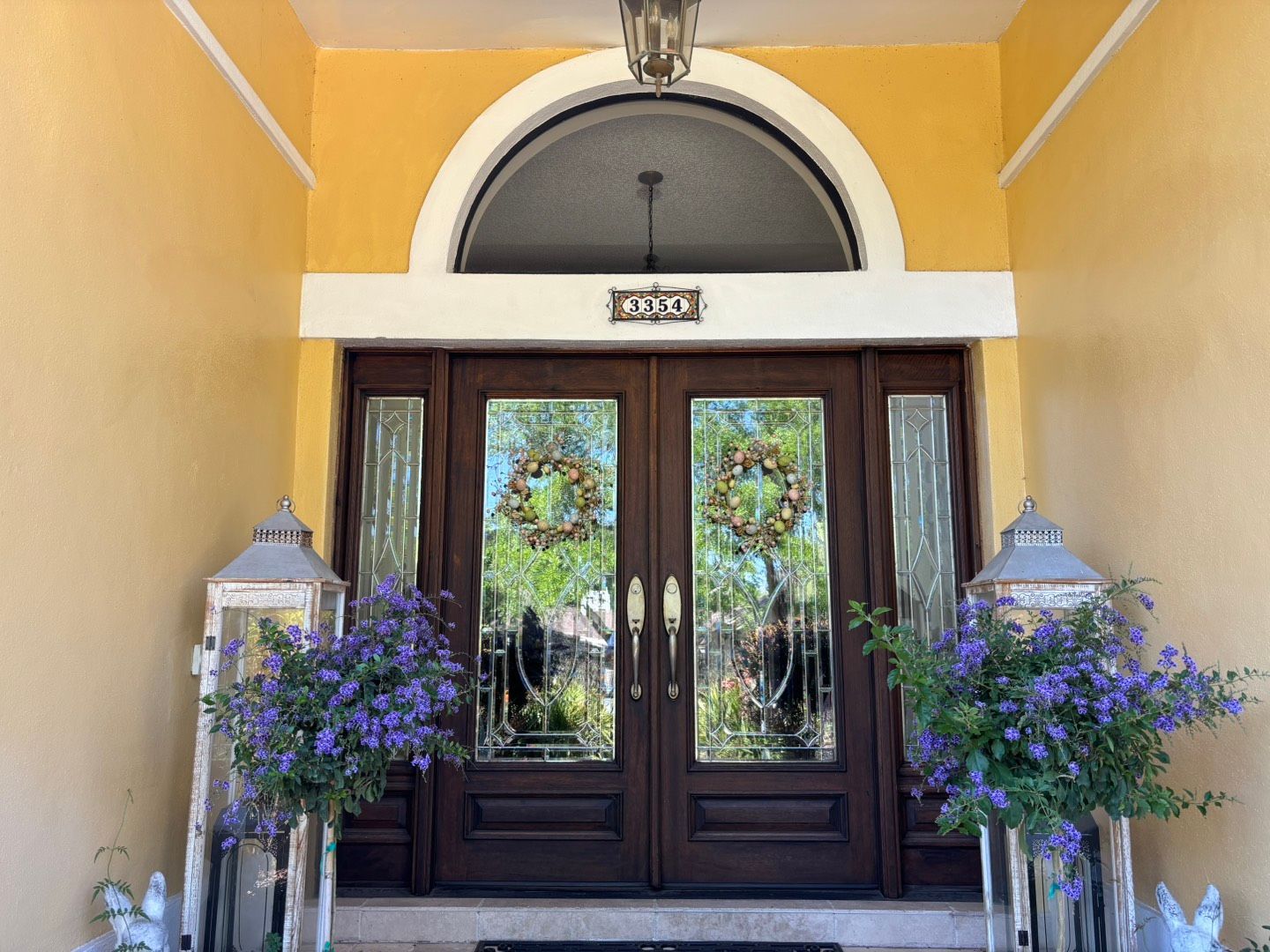 A woman is cleaning a window with a spray bottle.