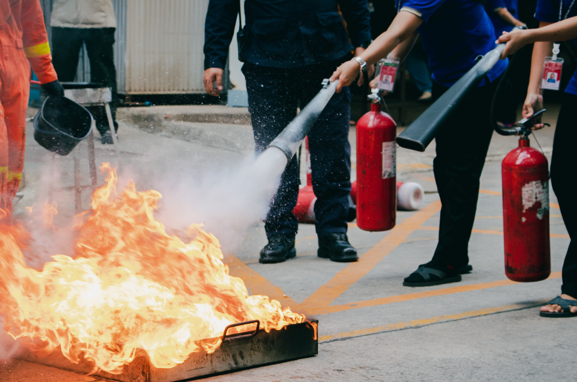 A group of people are using fire extinguishers to put out a fire.