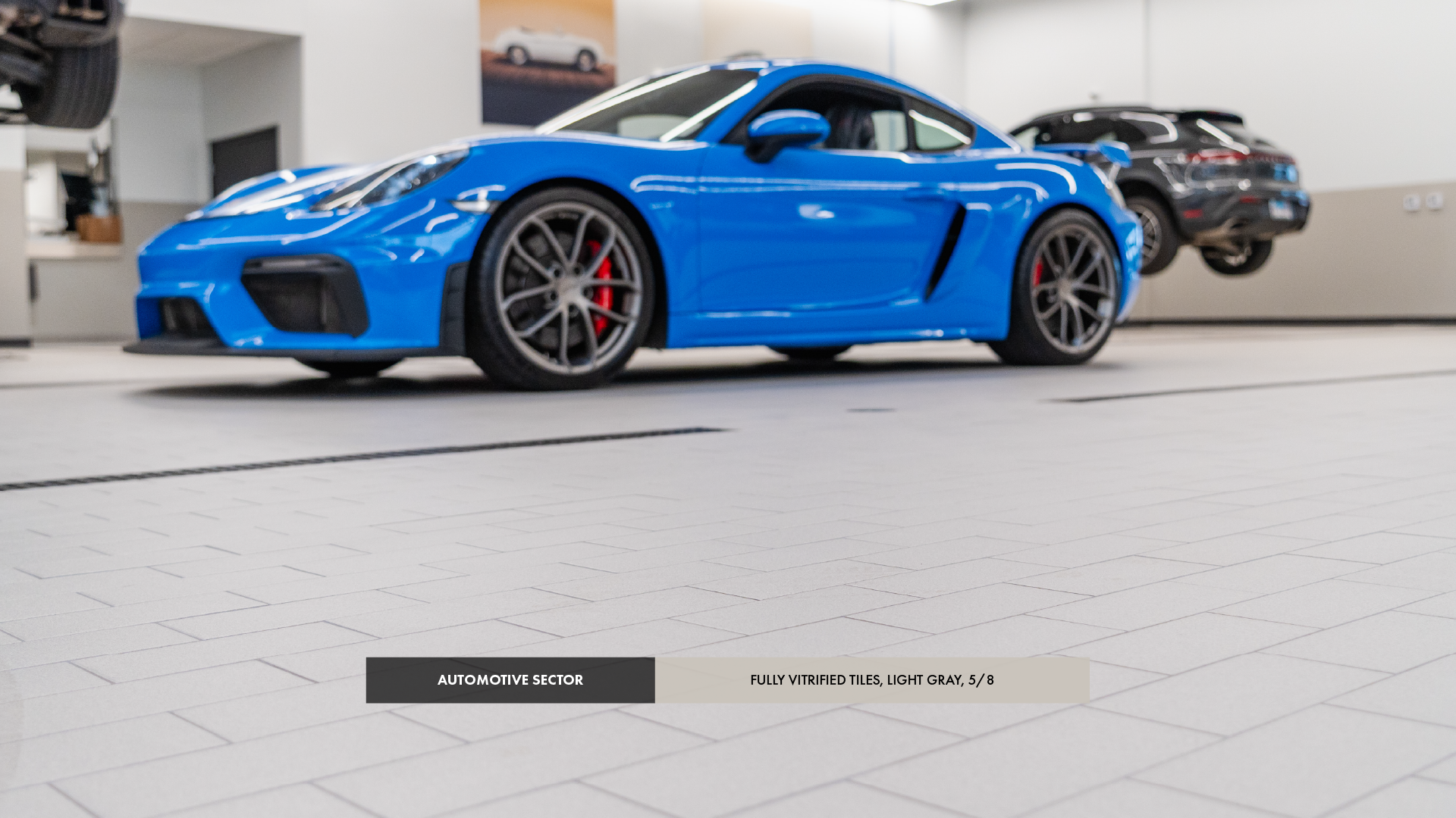 A blue Porsche standing on tiles in a garage.