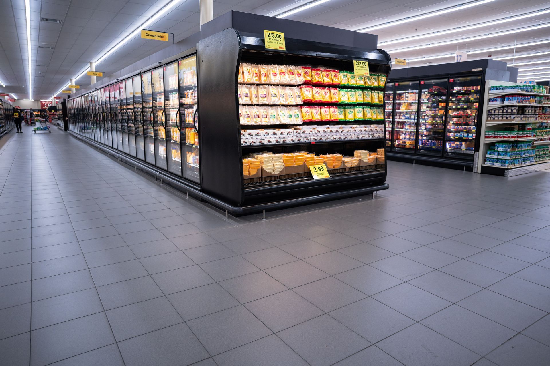 The cold section of a grocery store with grey tile flooring.