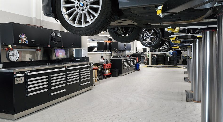 A car is sitting on a lift in a garage.