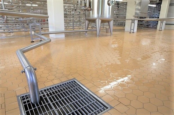 There is a drain on the floor in a factory.