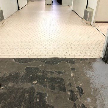 A hallway with a tiled floor and a concrete floor.