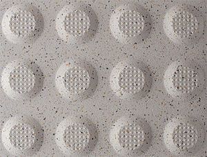 A close up of a white tile with circles on it.