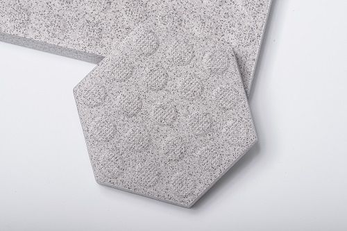 A close up of a hexagon shaped tile on a white surface.