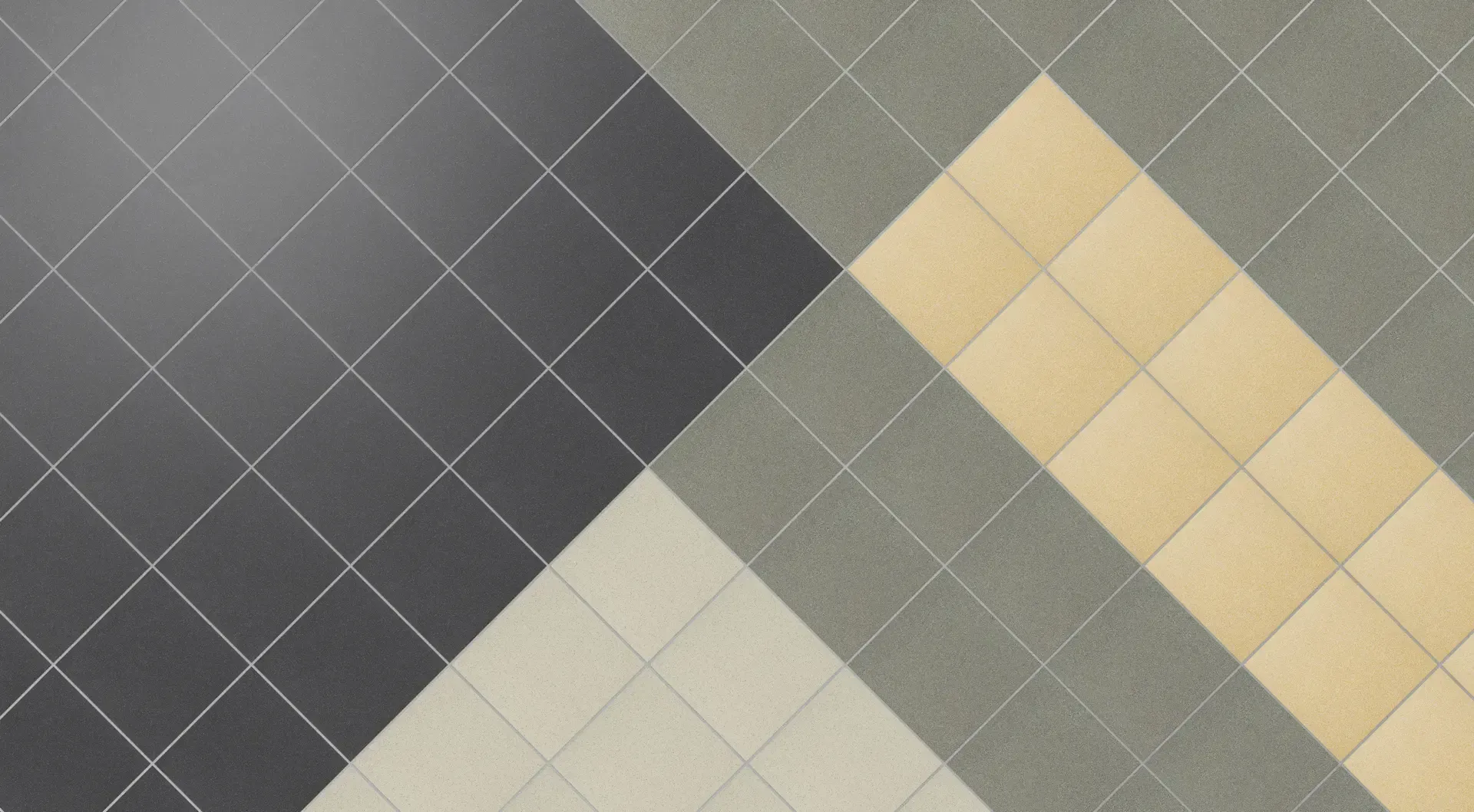A top-down view of tiled flooring in diagonal patterns of black, grey, cream, and beige.