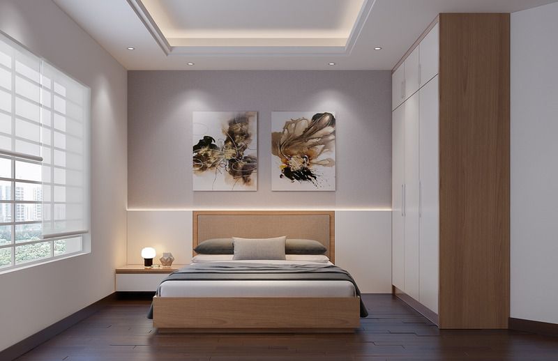 A bedroom with a bed and two paintings on the wall.