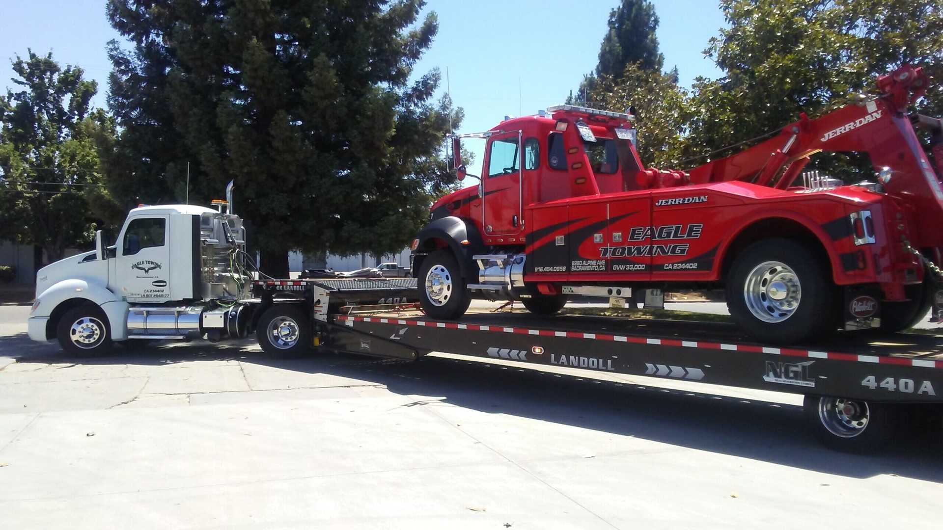 White Tow Truck Carrying Red Truck — Lockouts in Sacramento, CA