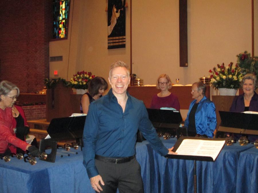 A man in a blue shirt stands in front of a group of people