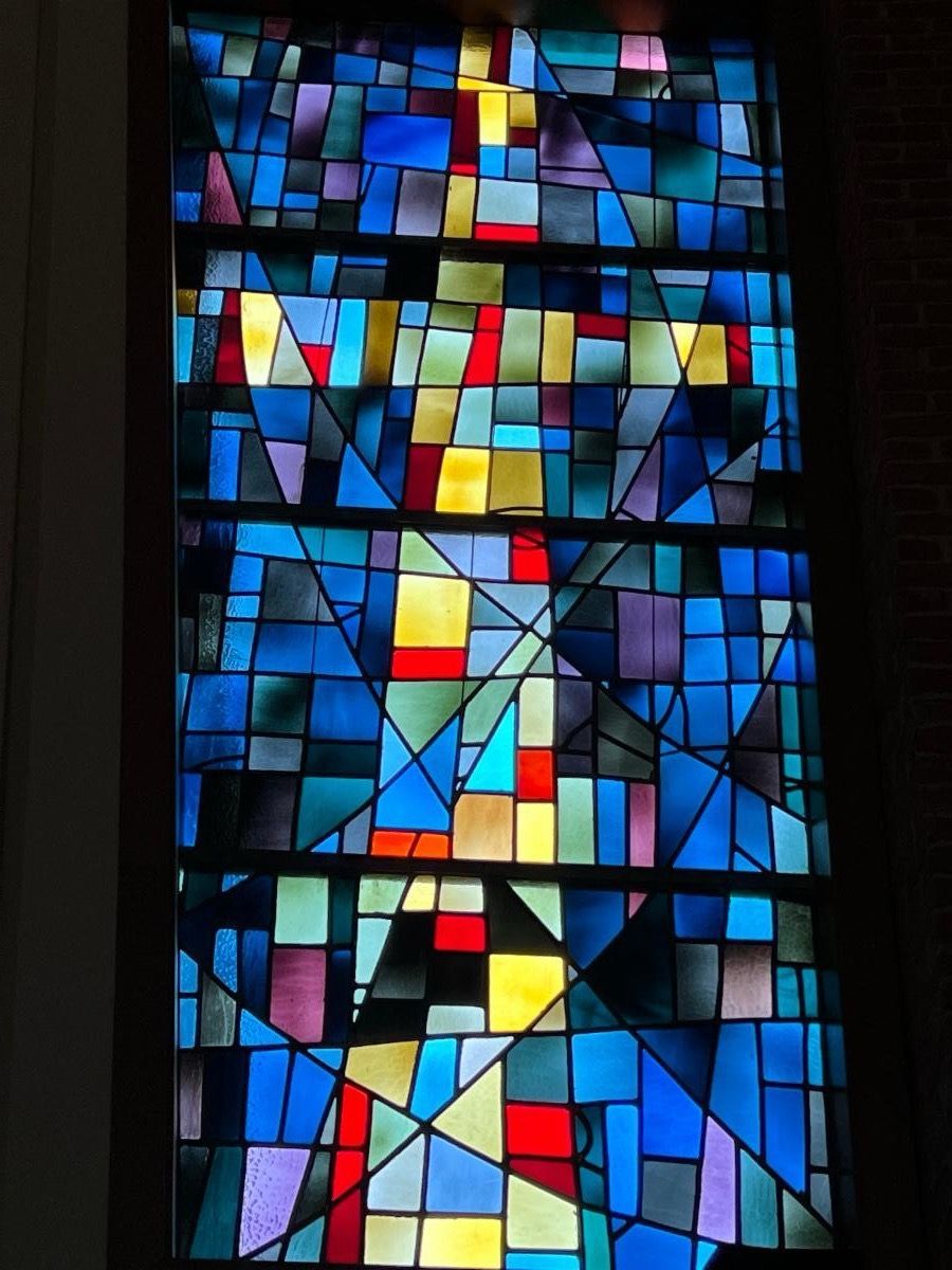 A colorful stained glass window in a dark room