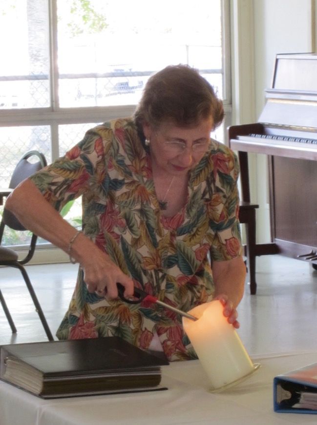 A woman is cutting a candle with a pair of scissors