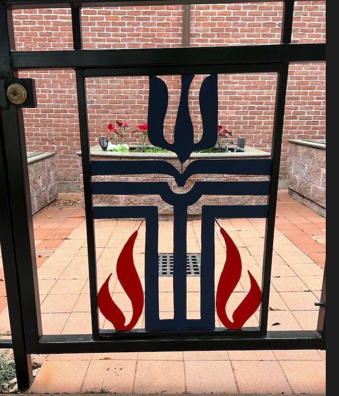 A gate with a cross and flames on it