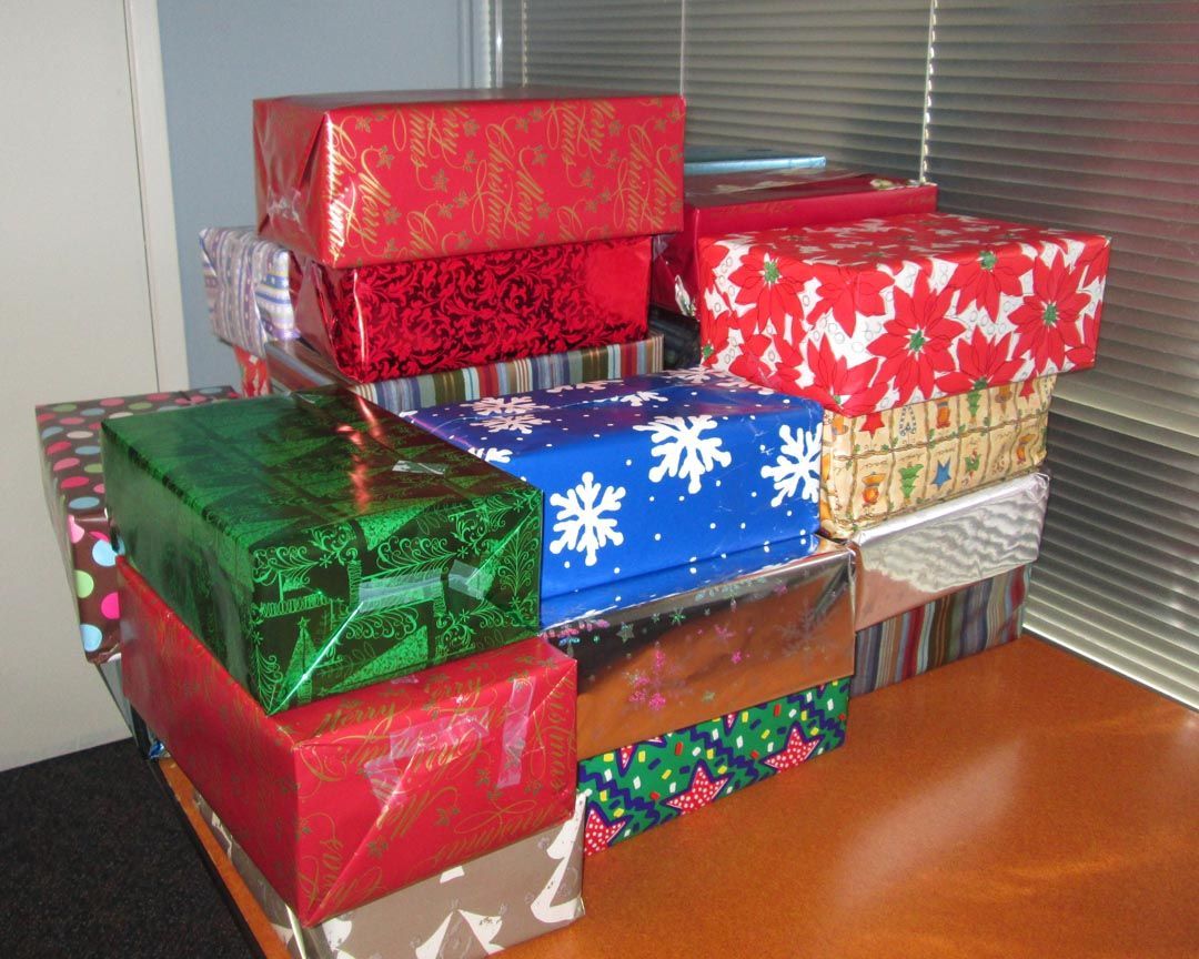 A stack of wrapped christmas presents on a table