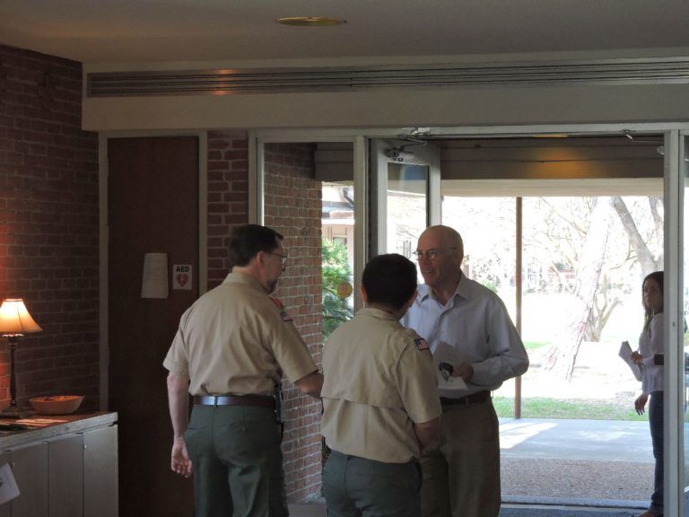 A group of men are standing in a doorway talking to each other