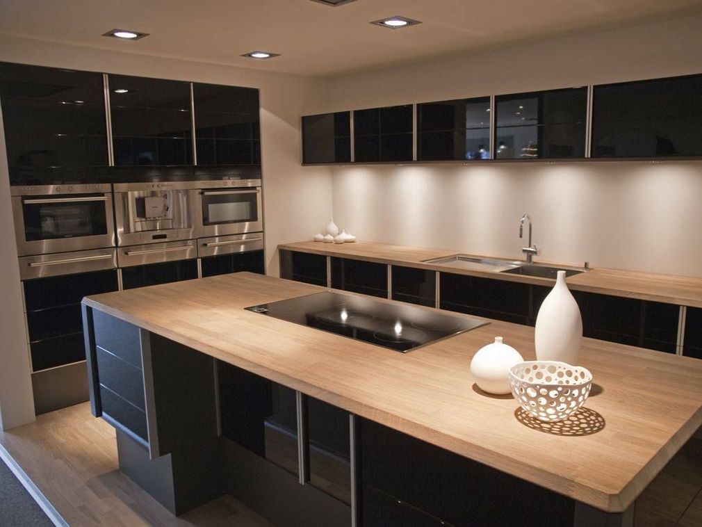 A kitchen with black cabinets and wooden counter tops