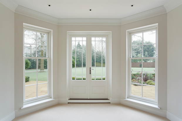 An empty room with lots of windows and a door