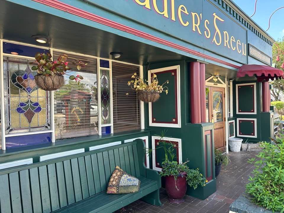 A restaurant with a green bench in front of it