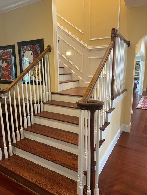 A staircase with wooden steps and white railings in a house.