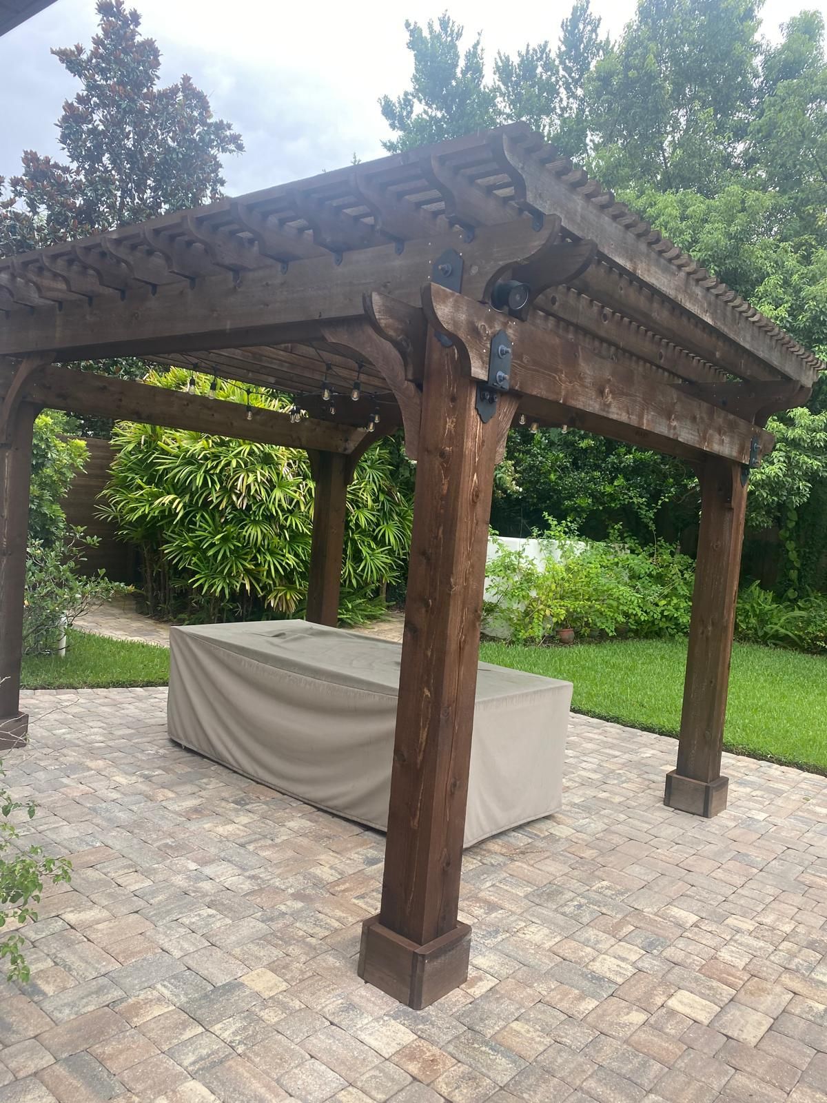 A wooden pergola with a table underneath it.