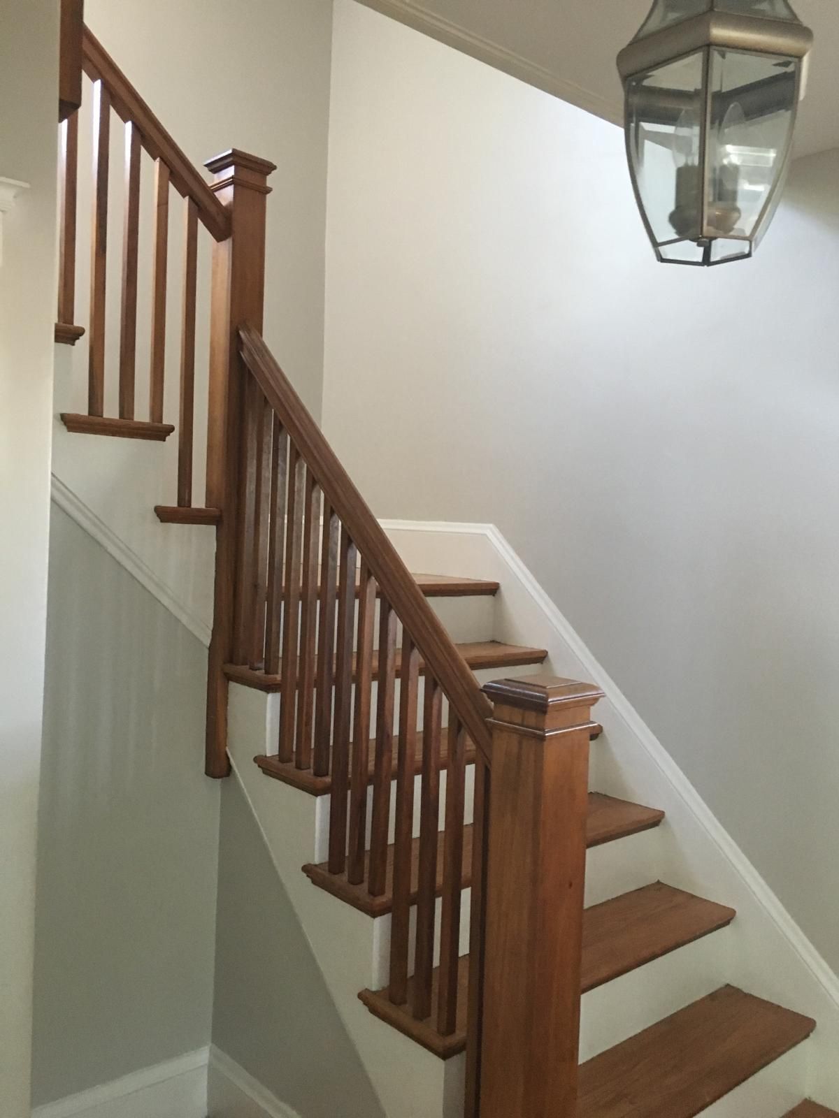 A wooden staircase with a lantern hanging from the ceiling