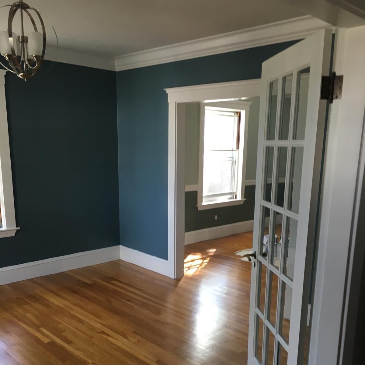 An empty room with blue walls and hardwood floors