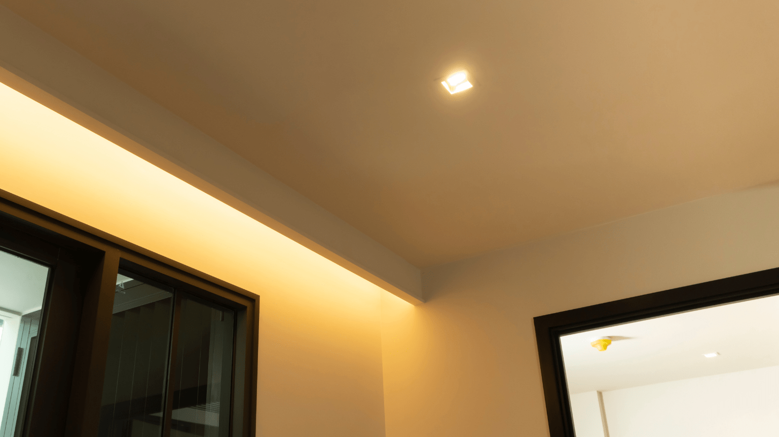 Ceiling with recessed lighting, illuminated strip light, and dark-framed windows and doorway — Intolec Electrical In Tweed Heads, NSW