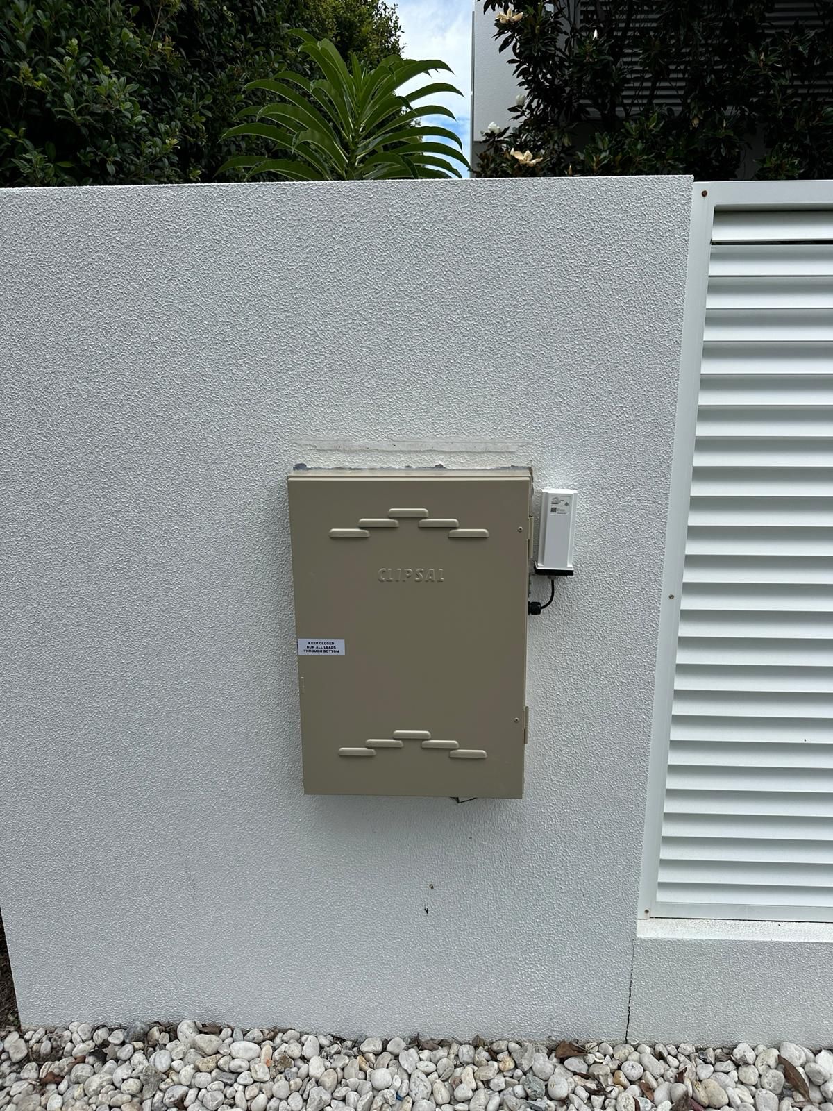 Gray Electrical Box Mounted on a Textured Light Gray Wall — Intolec Electrical in Tweed Heads, NSW