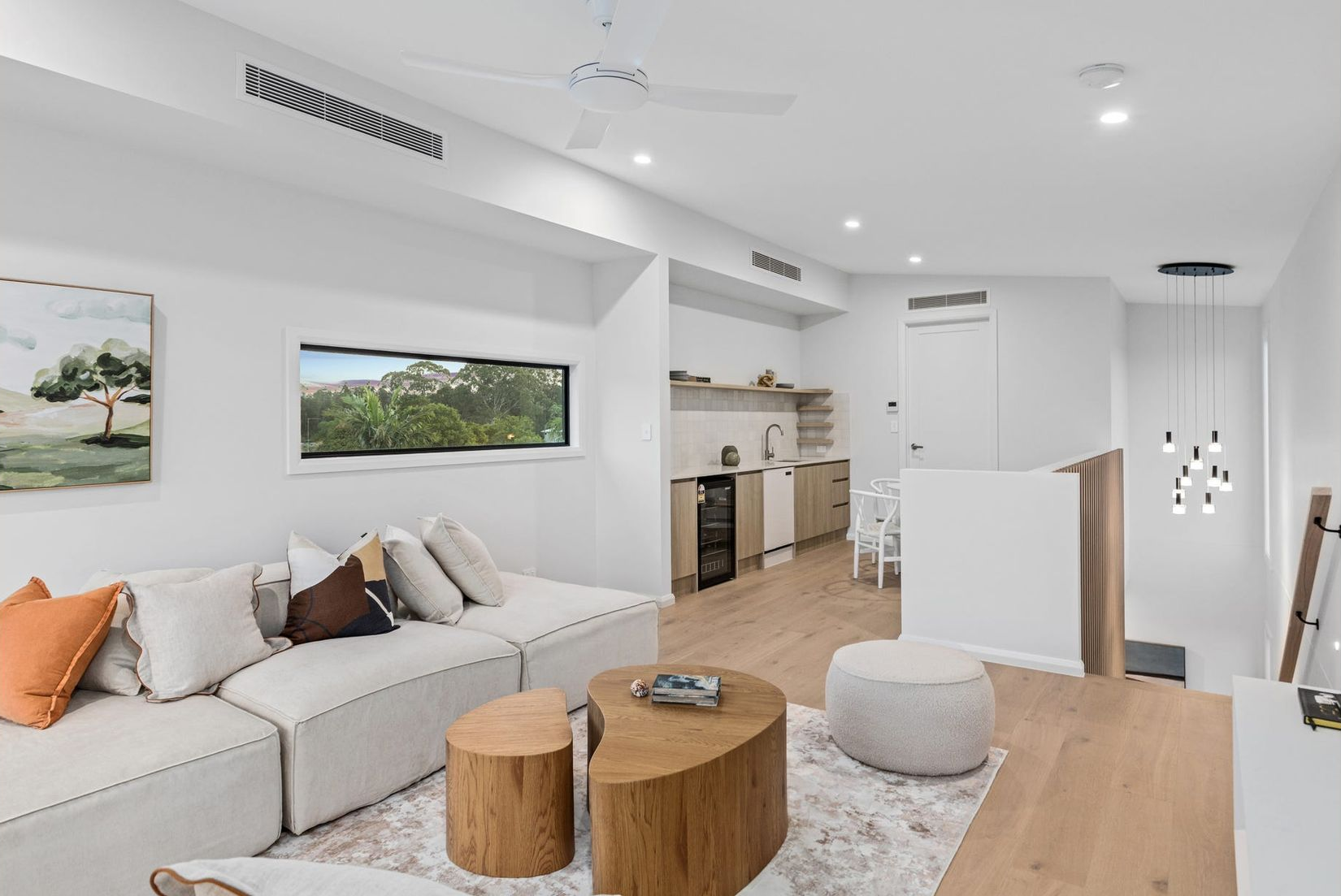 Night view of a house with a stone wall, driveway, and a tree with lights illuminating the structure. — Intolec Electrical In Tweed Heads, NSW