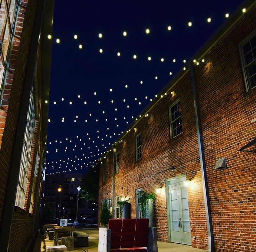 Brick buildings lit by strings of lights at night. — Intolec Electrical In Tweed Heads, NSW