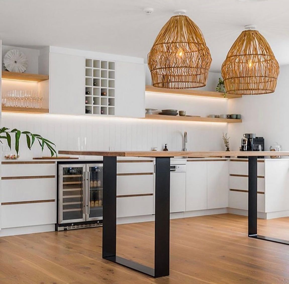 Kitchen with white cabinets, a wine cooler, a wooden bar, and two wicker pendant lights. — Intolec Electrical In Tweed Heads, NSW