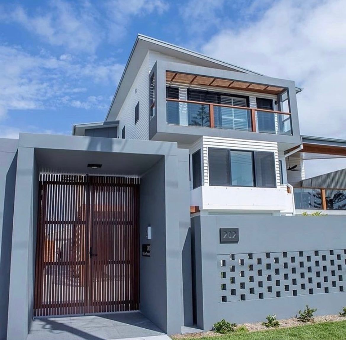 Modern gray house with a bamboo gate and decorative wall, under a blue sky. — Intolec Electrical In Tweed Heads, NSW