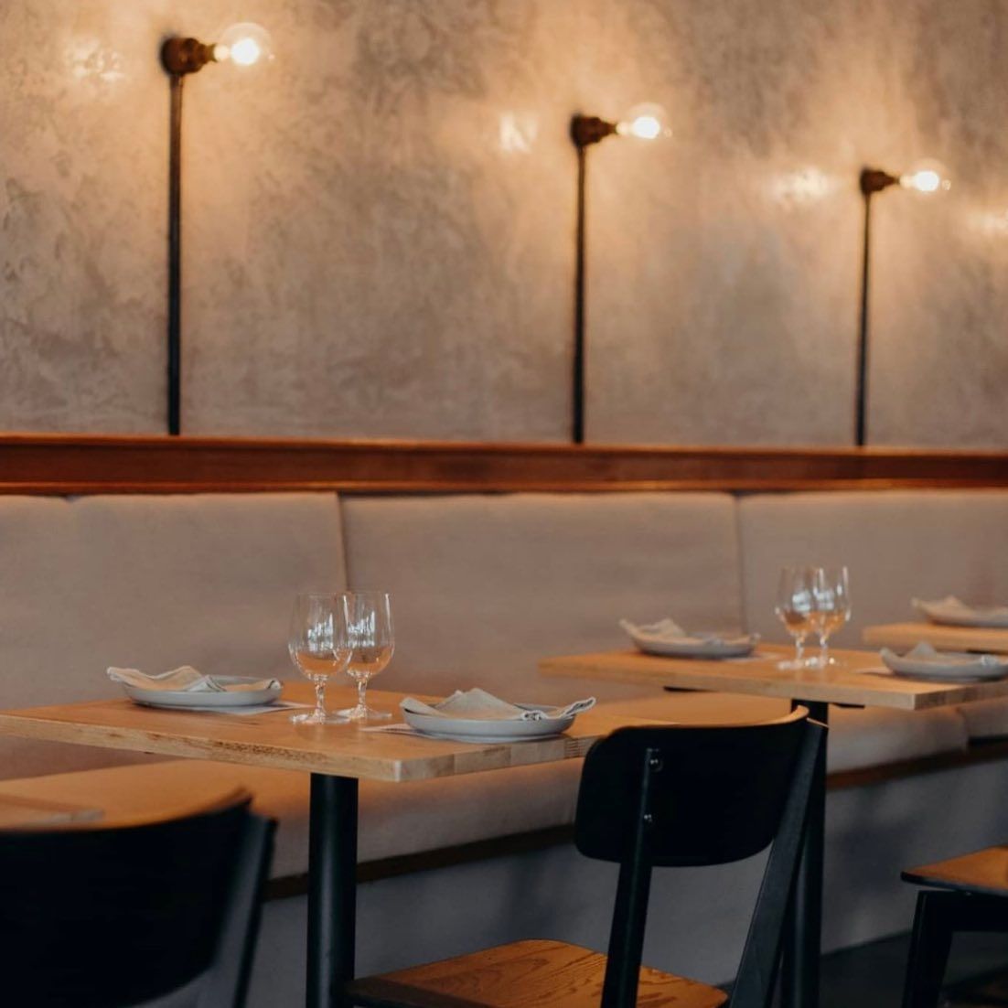 Restaurant interior with tables, chairs, and wall-mounted lights. — Intolec Electrical In Tweed Heads, NSW