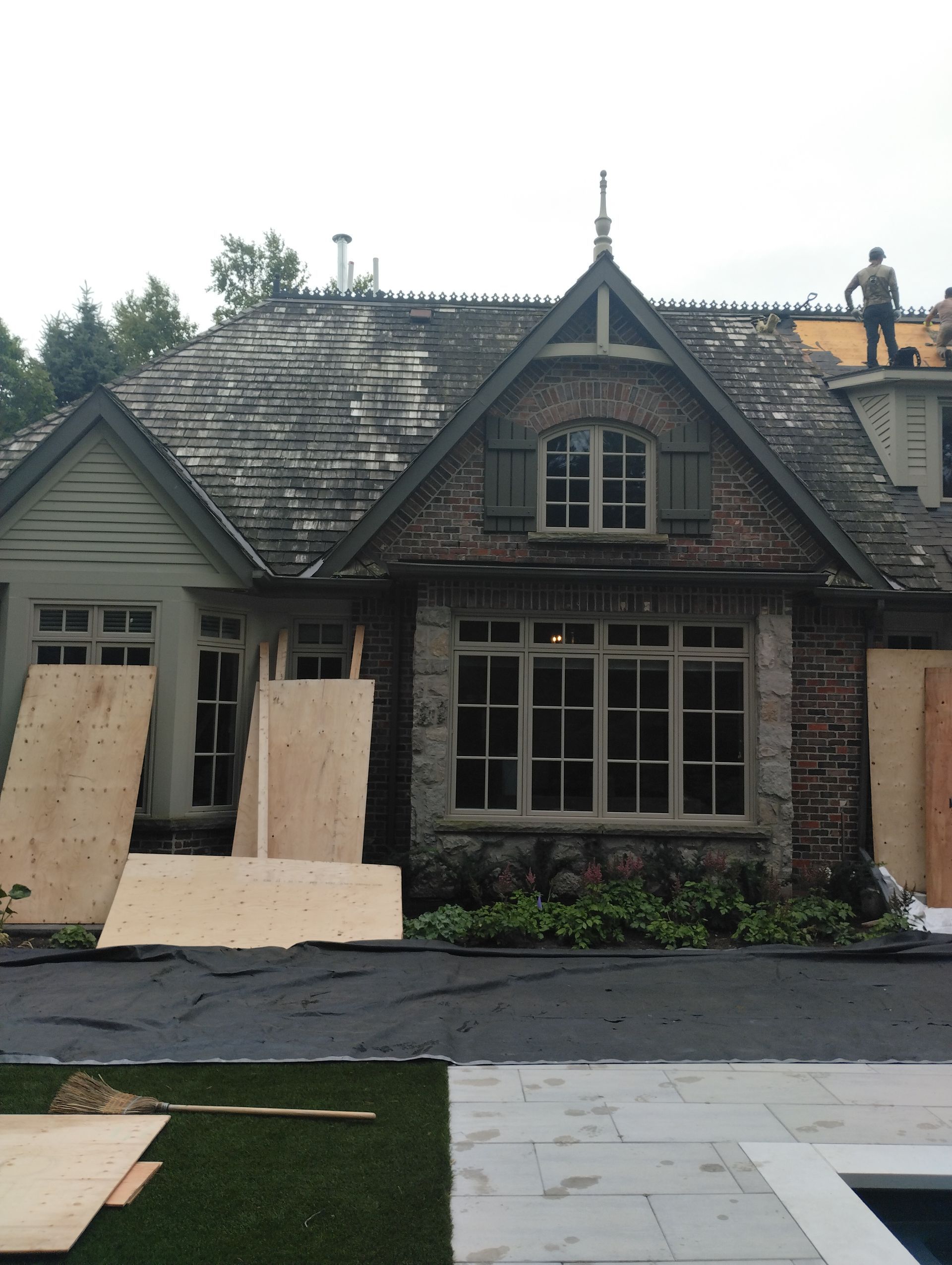 A man is standing on the roof of a house